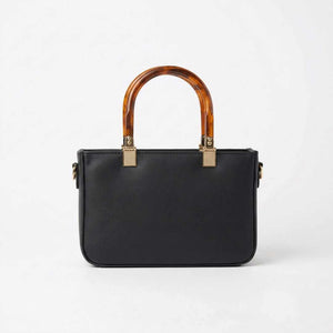 Black handbag with tortoiseshell handles on a white background