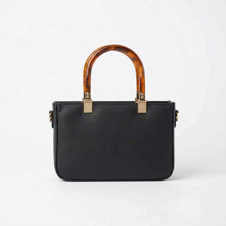 Black handbag with tortoiseshell handles on a white background