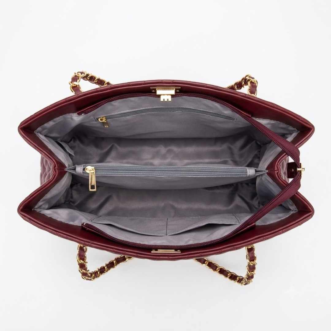 Open red handbag with gold chain detail on a white background