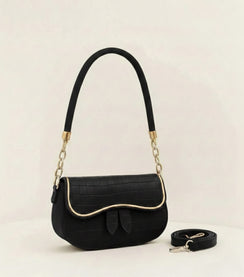 Black handbag with gold accents on a light beige background